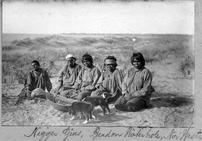 A group of people sitting on the ground. 